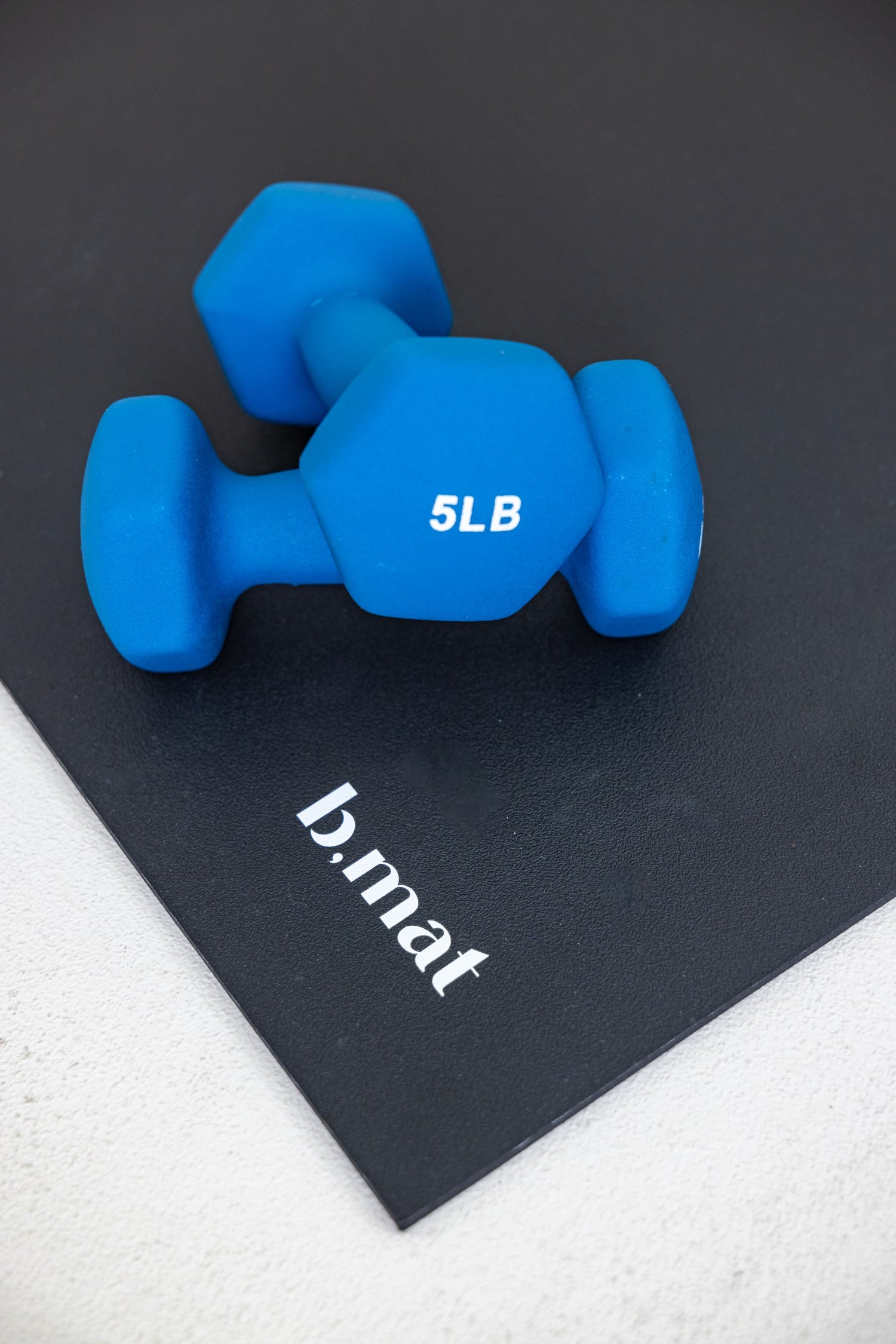 blue five pound weights on bmat yoga mat