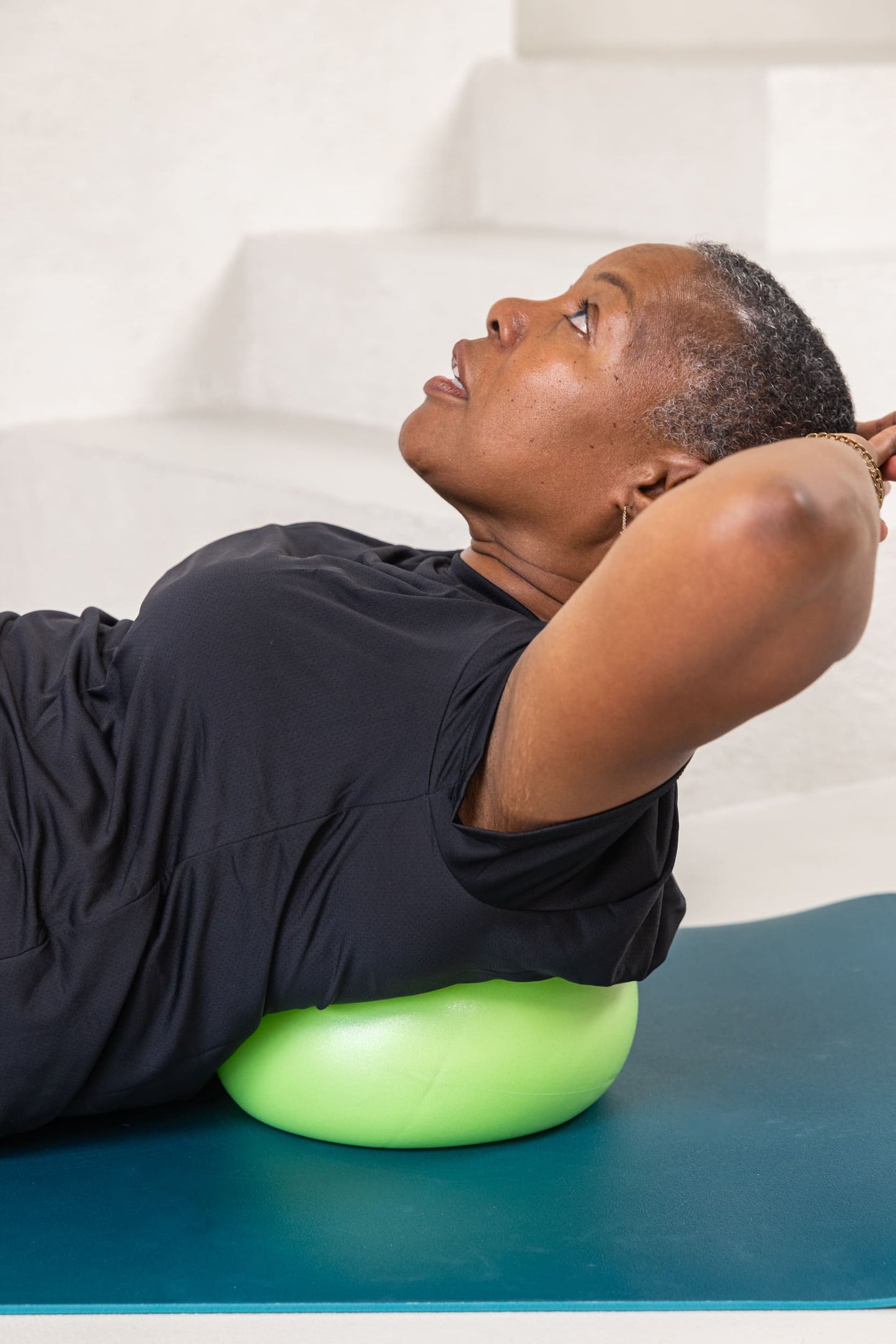 older women lying on an exercise ball for core strength