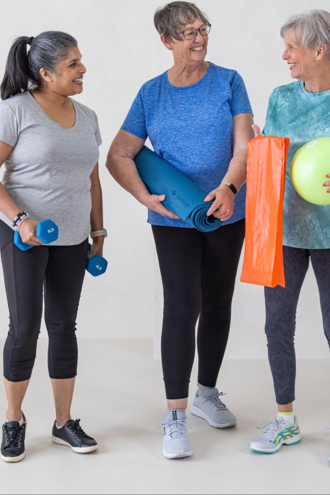 Three Older Women Holding Fitness Equipment